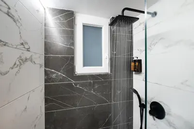 a bathroom with a shower with a window at apt Eleven - cozy apartment with garden in Athens