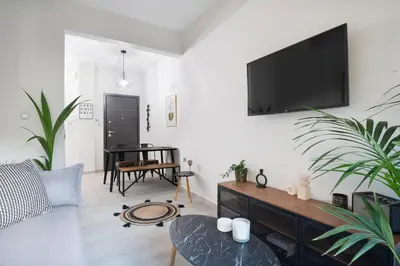 a living room with a couch and a tv on a wall at apt Eleven - cozy apartment with garden in Athens