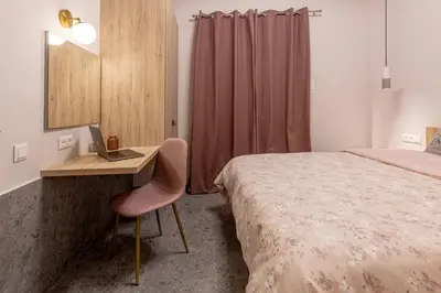 a bedroom with a bed and a desk with a laptop at Elegant Apt 5' from Ampelokipi Metro Station in Athens