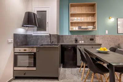 a kitchen with a sink and a table with chairs at Elegant Apt 5' from Ampelokipi Metro Station in Athens