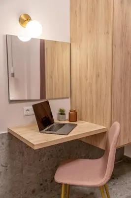 a laptop computer sitting on a wooden desk with a chair at Elegant Apt 5' from Ampelokipi Metro Station in Athens