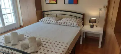 a bedroom with a bed with pillows and a table at Lobelia Athens Centre -5 BD, 2.5 BATH in Athens