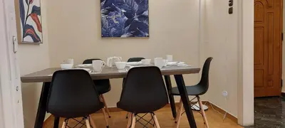 a dining room table with four chairs around it at Lobelia Athens Centre -5 BD, 2.5 BATH in Athens