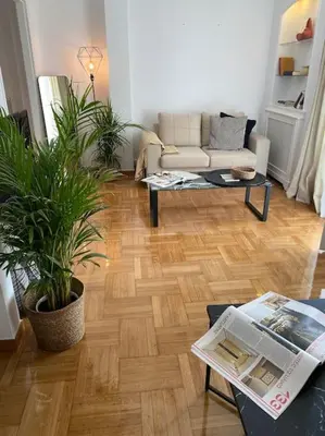 a living room with a couch and two potted plants at Kolonaki Oasis in Athens