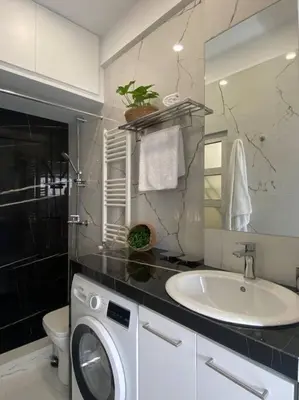 a bathroom with a washing machine and a sink at Kolonaki Oasis in Athens