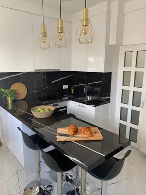 a kitchen with a black counter with croissants on a cutting board at Kolonaki Oasis in Athens