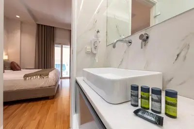 a white bathroom with a sink and a bed at Phaedrus Living City Center Luxury Flat Neos Kosmos in Athens