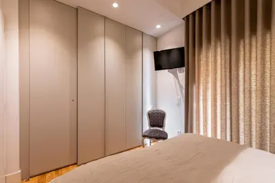 a bedroom with a bed and a chair at Phaedrus Living City Center Luxury Flat Neos Kosmos in Athens