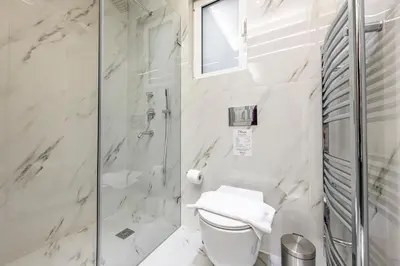 a white bathroom with a shower and a toilet at Phaedrus Living City Center Luxury Flat Neos Kosmos in Athens