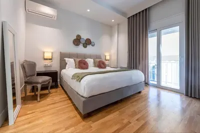 a bedroom with a large bed and a chair at Phaedrus Living City Center Luxury Flat Neos Kosmos in Athens