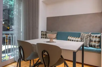 a table and chairs in a living room with a couch at Phaedrus Living City Center Lux Flat Kolonaki in Athens
