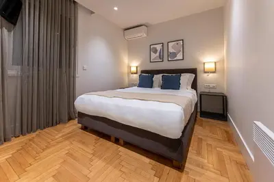 a bedroom with a large bed with blue pillows at Phaedrus Living City Center Lux Flat Kolonaki in Athens