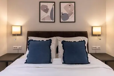 a bedroom with a bed with blue pillows and two lights at Phaedrus Living City Center Lux Flat Kolonaki in Athens