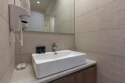 a bathroom with a white sink and a mirror at Phaedrus Living City Center Lux Flat Kolonaki in Athens