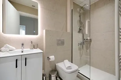 a bathroom with a shower and a toilet and a sink at Spacious 3-Bedroom Retreat in the Heart of Pagrati in Athens