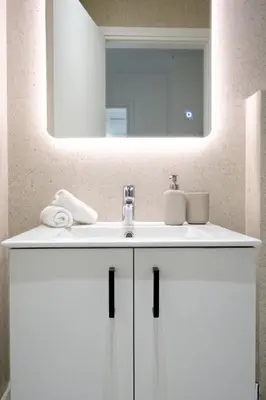 a bathroom with a white sink and a mirror at Spacious 3-Bedroom Retreat in the Heart of Pagrati in Athens