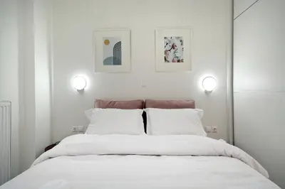 a bedroom with a large white bed with two lights at Spacious 3-Bedroom Retreat in the Heart of Pagrati in Athens