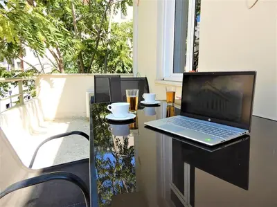 a laptop computer sitting on a glass table on a balcony at A-07! 2' walk 2 Acropolis Museum! 2BR-Sunny terrace! Extra fees for 2nd room in Athens