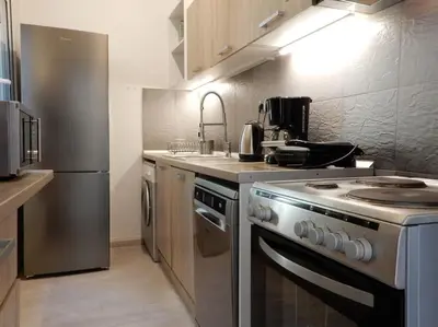 a kitchen with a stove and a stainless steel refrigerator at A-07! 2' walk 2 Acropolis Museum! 2BR-Sunny terrace! Extra fees for 2nd room in Athens