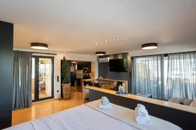 a bedroom with a bed and a living room at Athens Skyline Loft in Athens