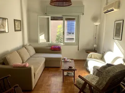 a living room with a couch and a table at Sunny calm apartment in pedestrian street in Athens