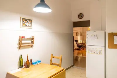 a kitchen with a wooden table and a refrigerator at Sunny calm apartment in pedestrian street in Athens