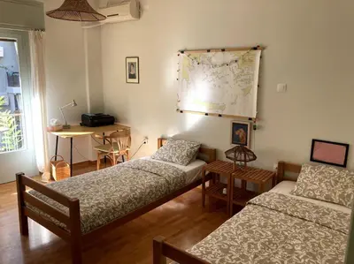 a room with two beds and a map on the wall at Sunny calm apartment in pedestrian street in Athens