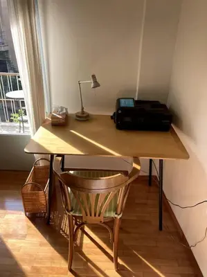 a wooden desk with a printer and a chair at Sunny calm apartment in pedestrian street in Athens