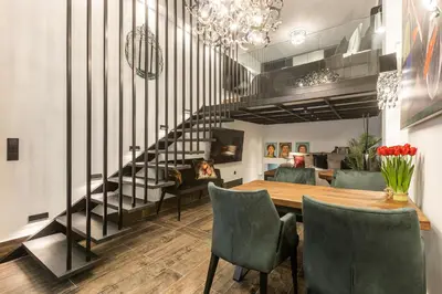 a dining room with a table and a spiral staircase at BookRoom in Athens