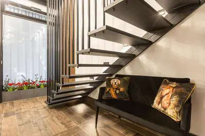 a staircase in a living room with a couch and a stair case at BookRoom in Athens
