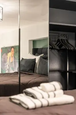 a mirror in a bedroom with a bed and a pile of towels at BookRoom in Athens