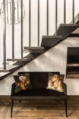a bench with two pillows sitting under a staircase at BookRoom in Athens