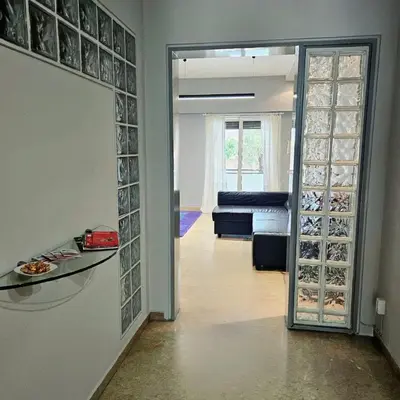 a living room with a glass door leading to a living room at Diocharous garden apartment in Athens