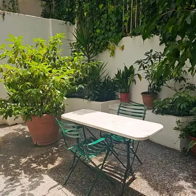 a white table and chairs in front of plants at Diocharous garden apartment in Athens