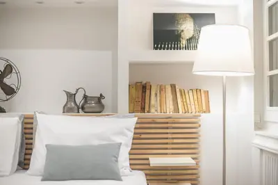 a room with a bed with a lamp and books at Charming apartment in Kolonaki, Peridot - Homes in Athens