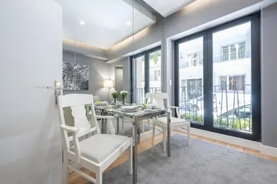 a dining room with a table and chairs and windows at Charming apartment in Kolonaki, Peridot - Homes in Athens