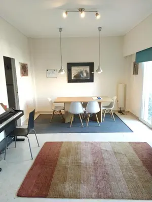 a dining room with a table and chairs and a piano at SAILORS LUXURY APPARTMENT 130m2 in Athens