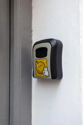 a button with a smiley face on it on a door at Central apartment in the heart of Historic Center in Athens