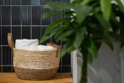a basket of towels sitting on a table next to a plant at apt Seventeen_2-bedroom flat_Athens citycentre in Athens