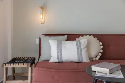 a living room with a red couch with a table at Lovely 1-bedroom apt with balcony in Athens