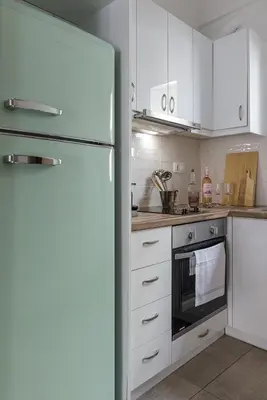 a kitchen with white cabinets and a refrigerator at Lovely 1-bedroom apt with balcony in Athens