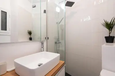 a white bathroom with a sink and a shower at Lovely 1-bedroom apt with balcony in Athens