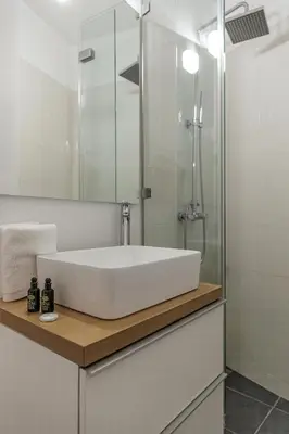 a bathroom with a white sink and a shower at Lovely 1-bedroom apt with balcony in Athens