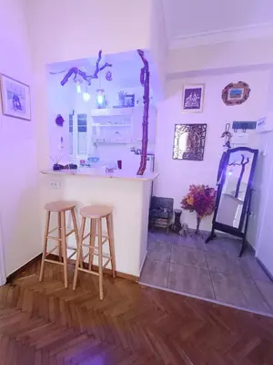 a kitchen with two stools and a counter in a room at Sweet home in Athens in Athens