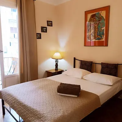 a bedroom with a large bed with a lamp and a window at Sweet home in Athens in Athens