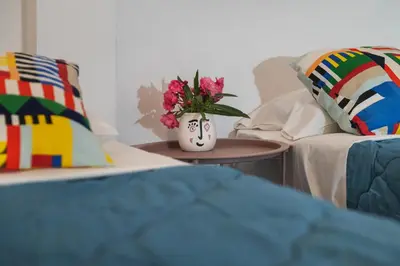 a vase with flowers on a table next to a couch at Friends & family 3broom apt, downtown Athens-FIX in Athens