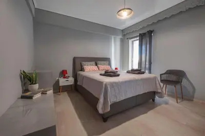 a bedroom with a bed and a window at Beautiful apt in Glyfada Center, Papandreou Street in Athens