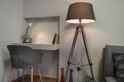 a lamp and a tripod in a room with a chair at Beautiful apt in Glyfada Center, Papandreou Street in Athens