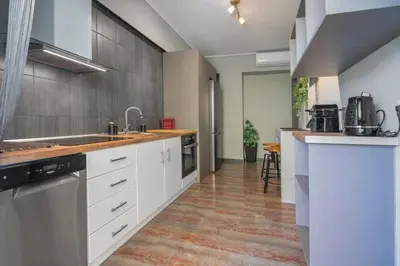 a kitchen with white cabinets and stainless steel appliances at Beautiful apt in Glyfada Center, Papandreou Street in Athens