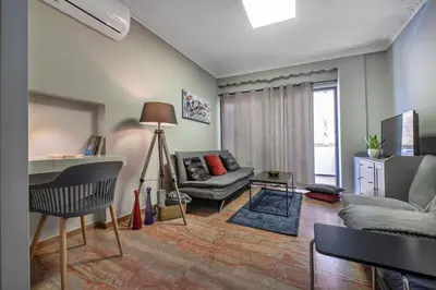a living room with a couch and a table at Beautiful apt in Glyfada Center, Papandreou Street in Athens